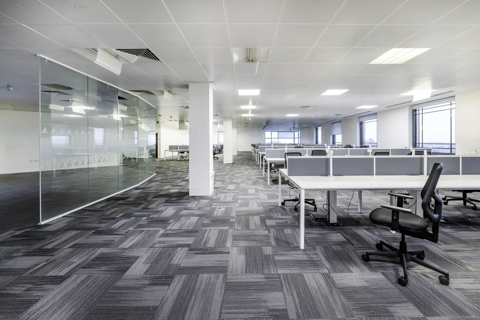 Fitted open-plan office with desks, task chairs and a glazed meeting room