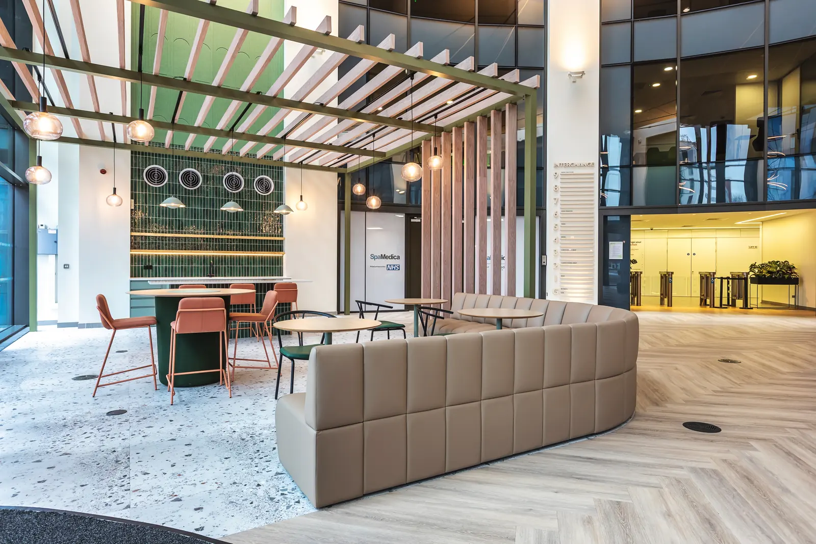 Reception lounge with sofas, high tables and a coffee bar under a timber pergola